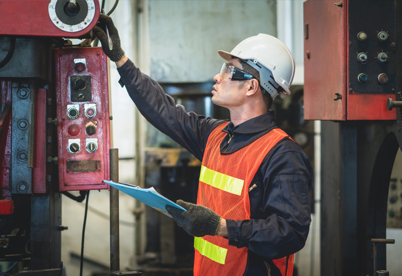 Worker interacting with industrial equipment controls during a human factors process safety review.