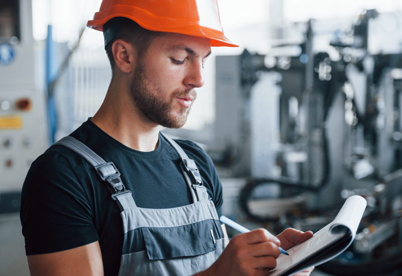Industrial worker reviewing an operating procedure for process safety and maintenance tasks.