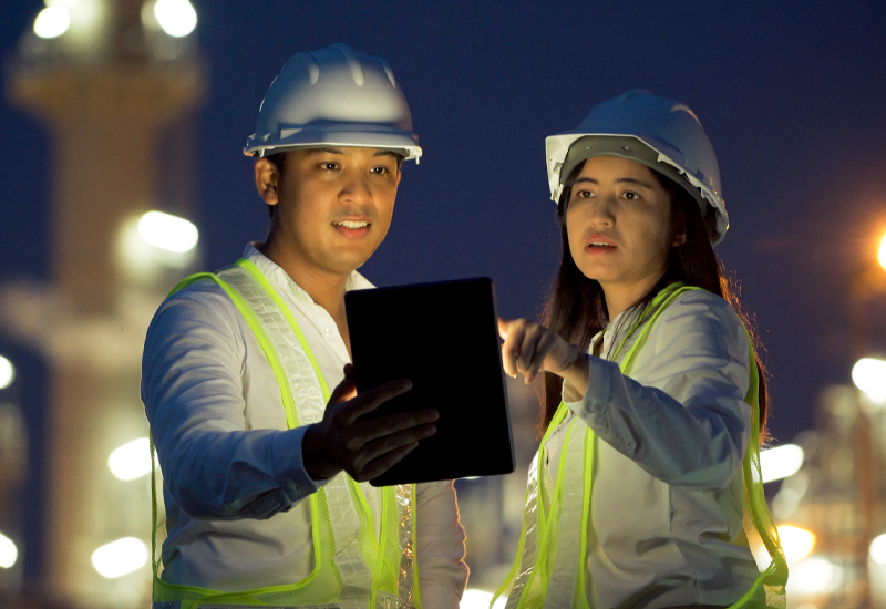 Two industrial workers reviewing process safety information during a HAZOP fundamentals training scenario.